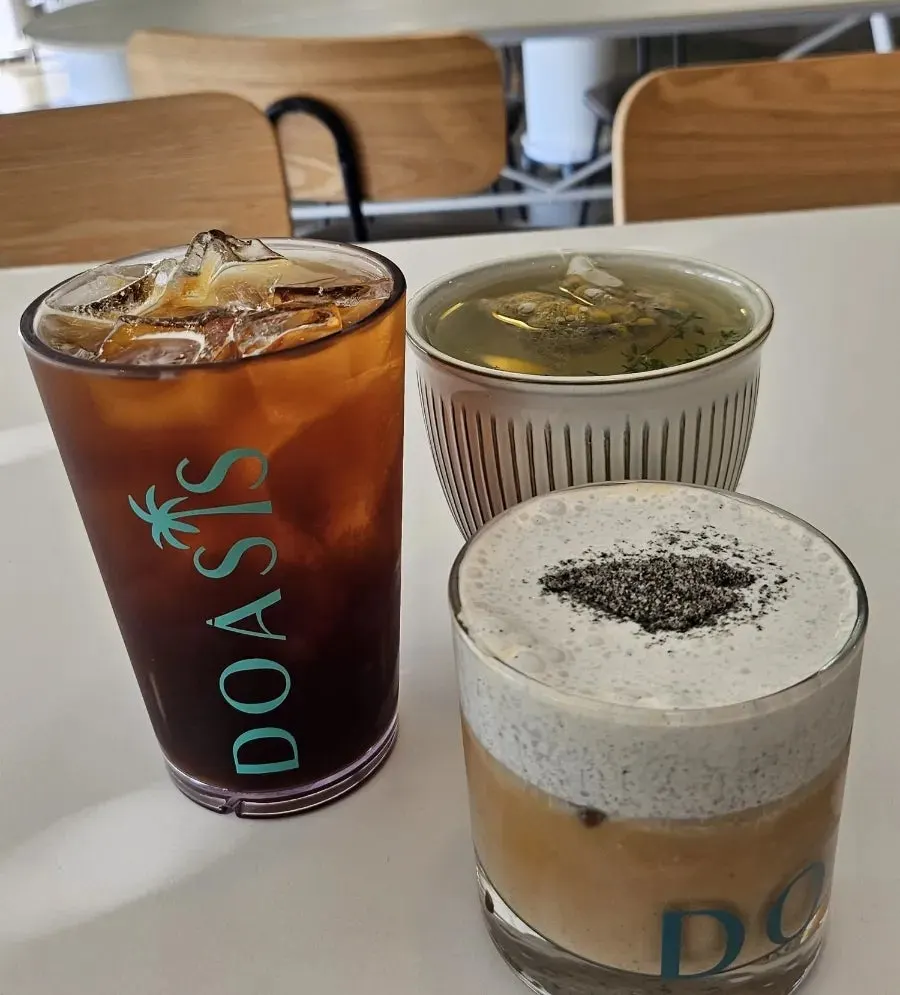 Black sesame cream latte at Doasis with the botanical-garden seating in the background