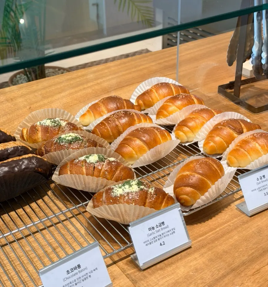Bakery display case with croissants and sausage bread