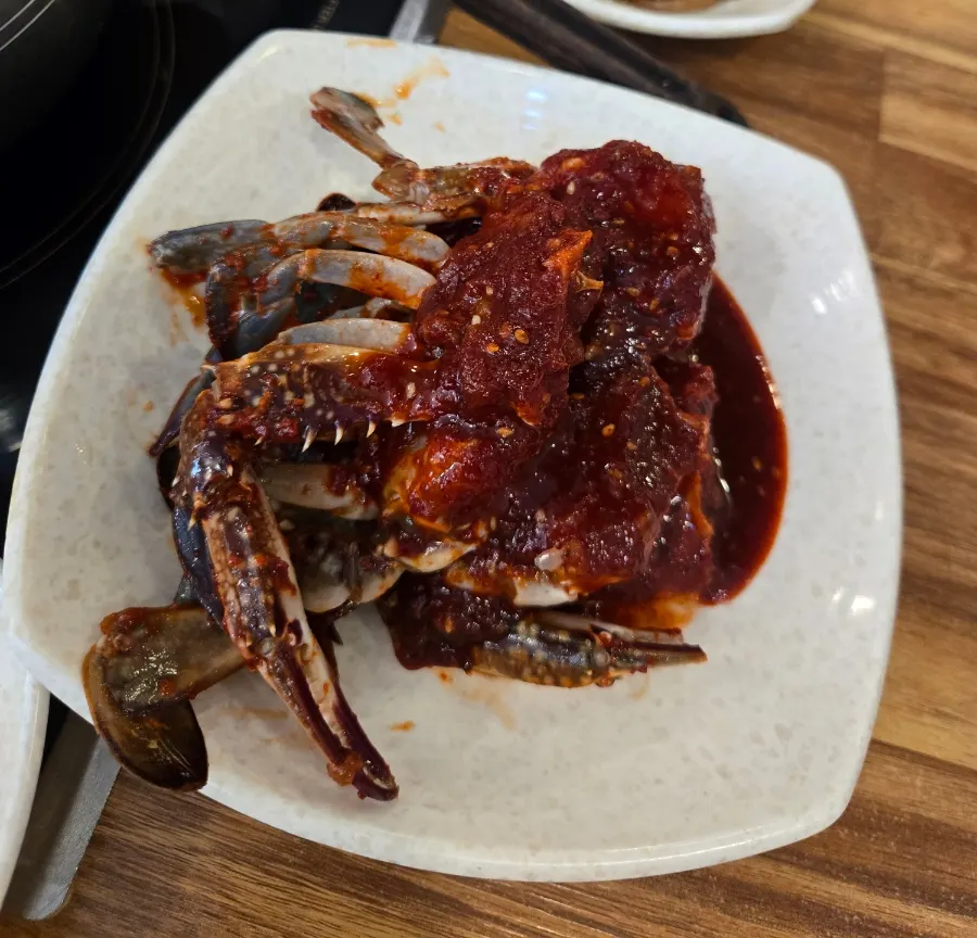 Bubbling crab stew next to a plate of crab