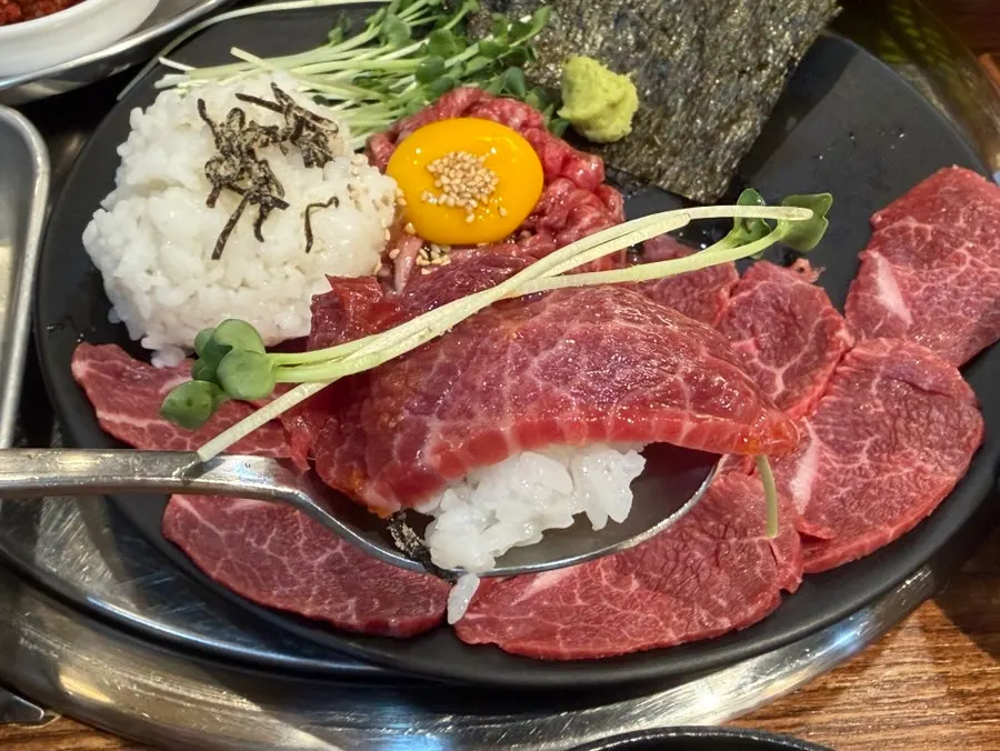 A piece of yuksashimi dipped in sauce