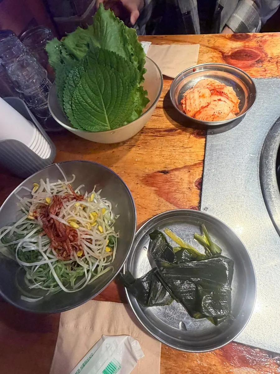 Table setting with three servings of scored pork belly and basic side dishes