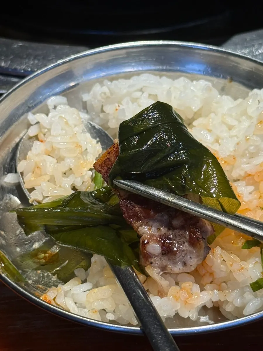 Pre-grilled pork belly and kimchi cooking on the pan