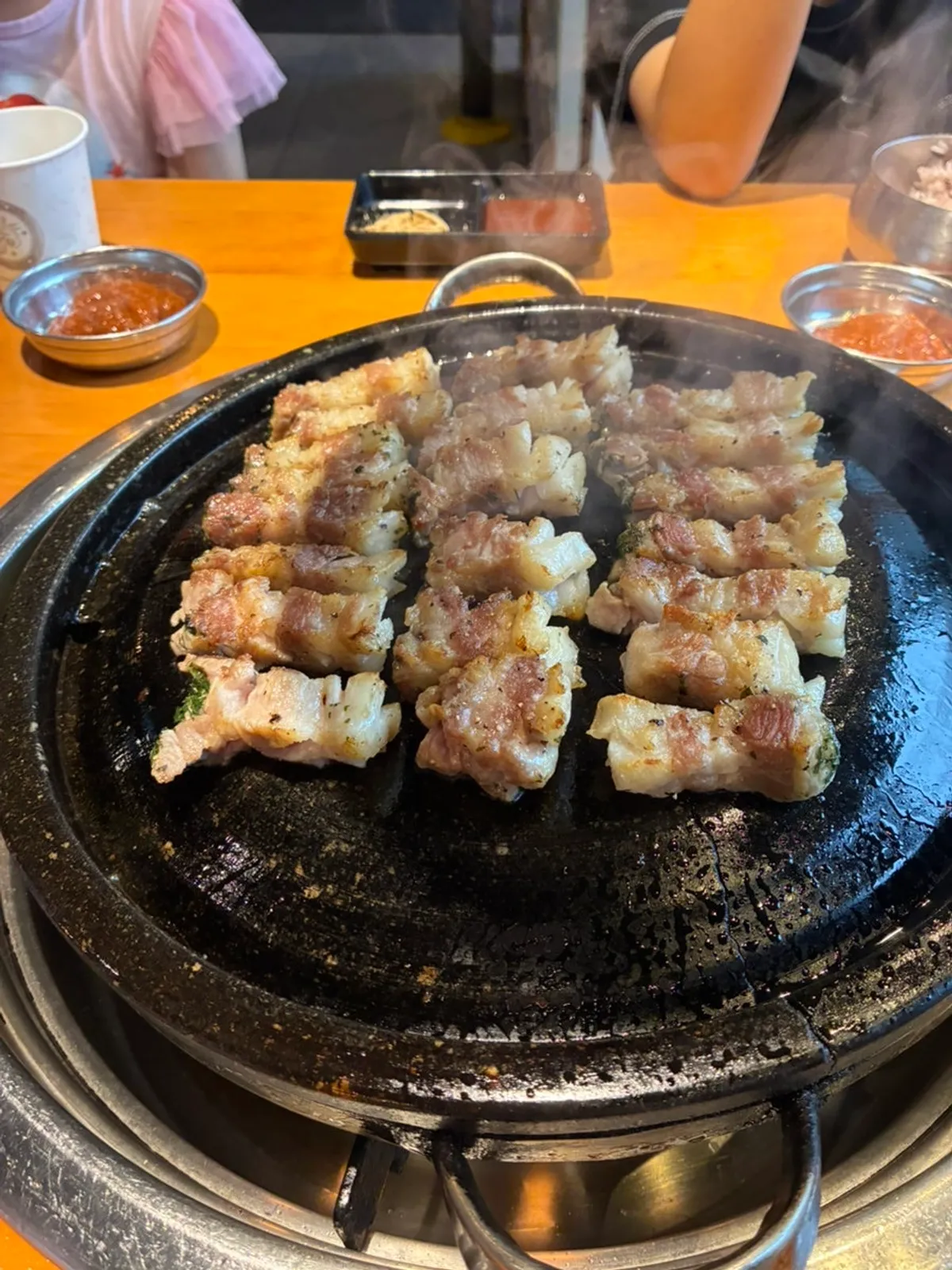 Thick knife-cut pork belly lined up on the grill