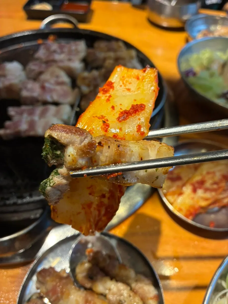 Knife-cut pork belly served on top of grilled kimchi