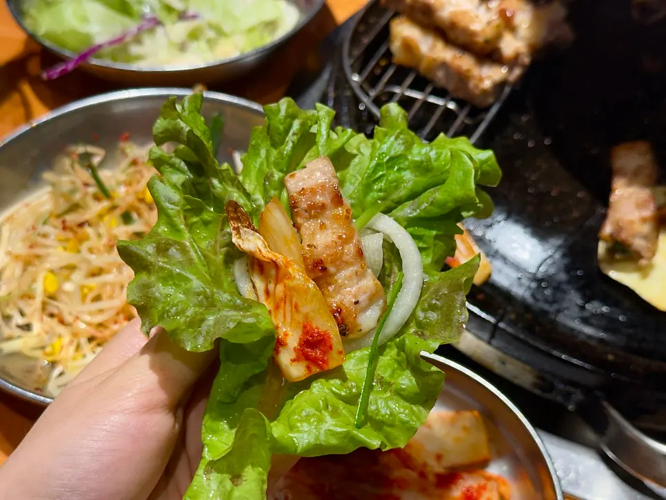 상추에 삼겹살과 양파 절임을 올린 쌈