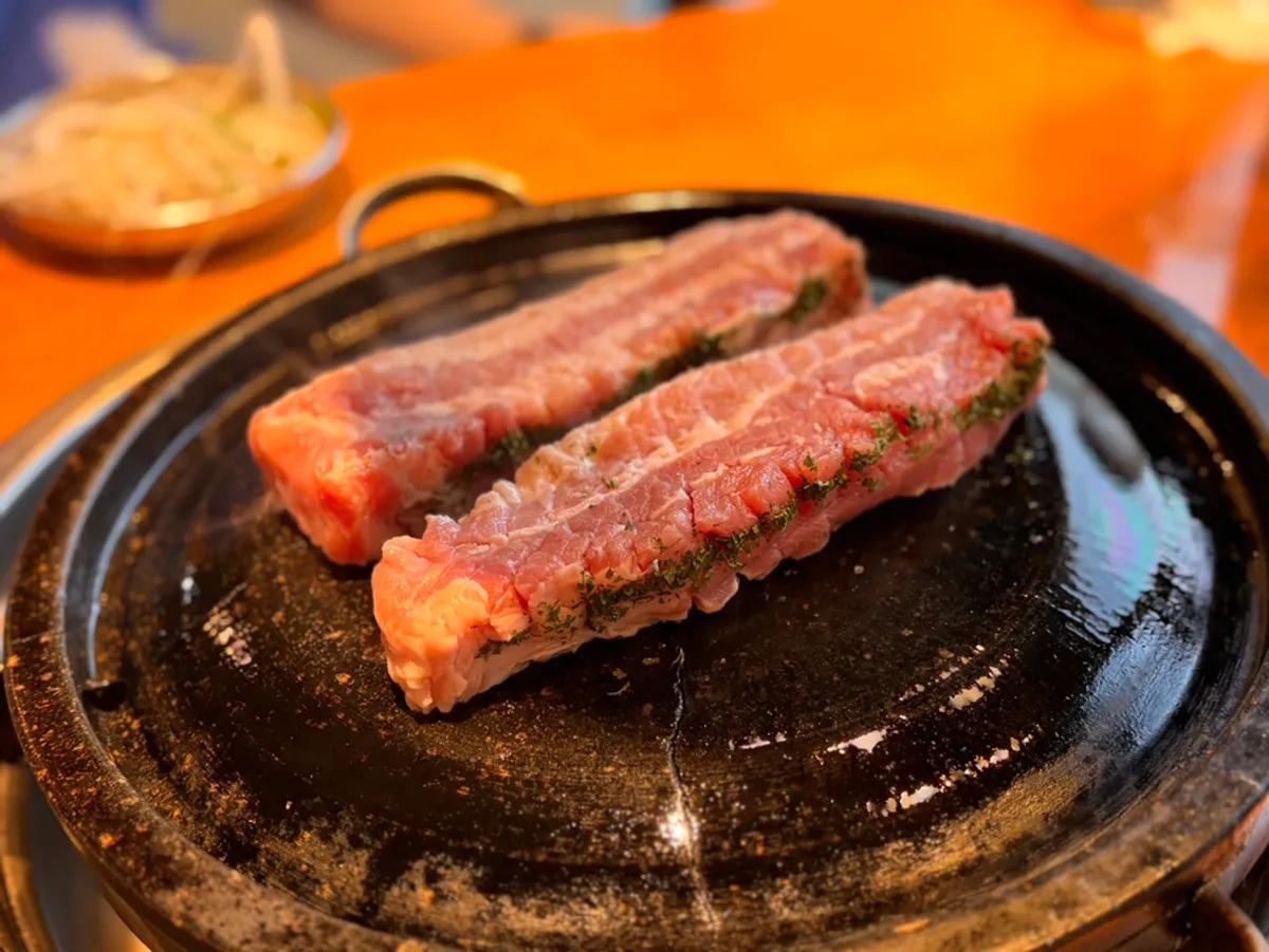 放在烤盤上的道賊水原店刀削五花肉
