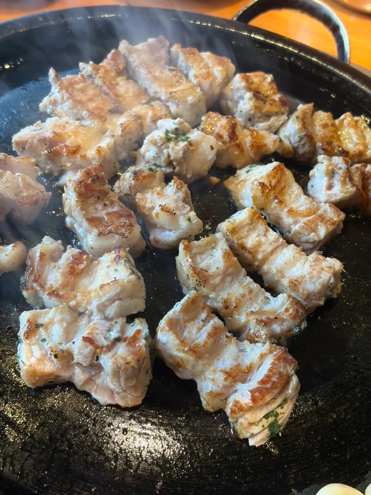 Knife-cut pork belly sizzling on the grill