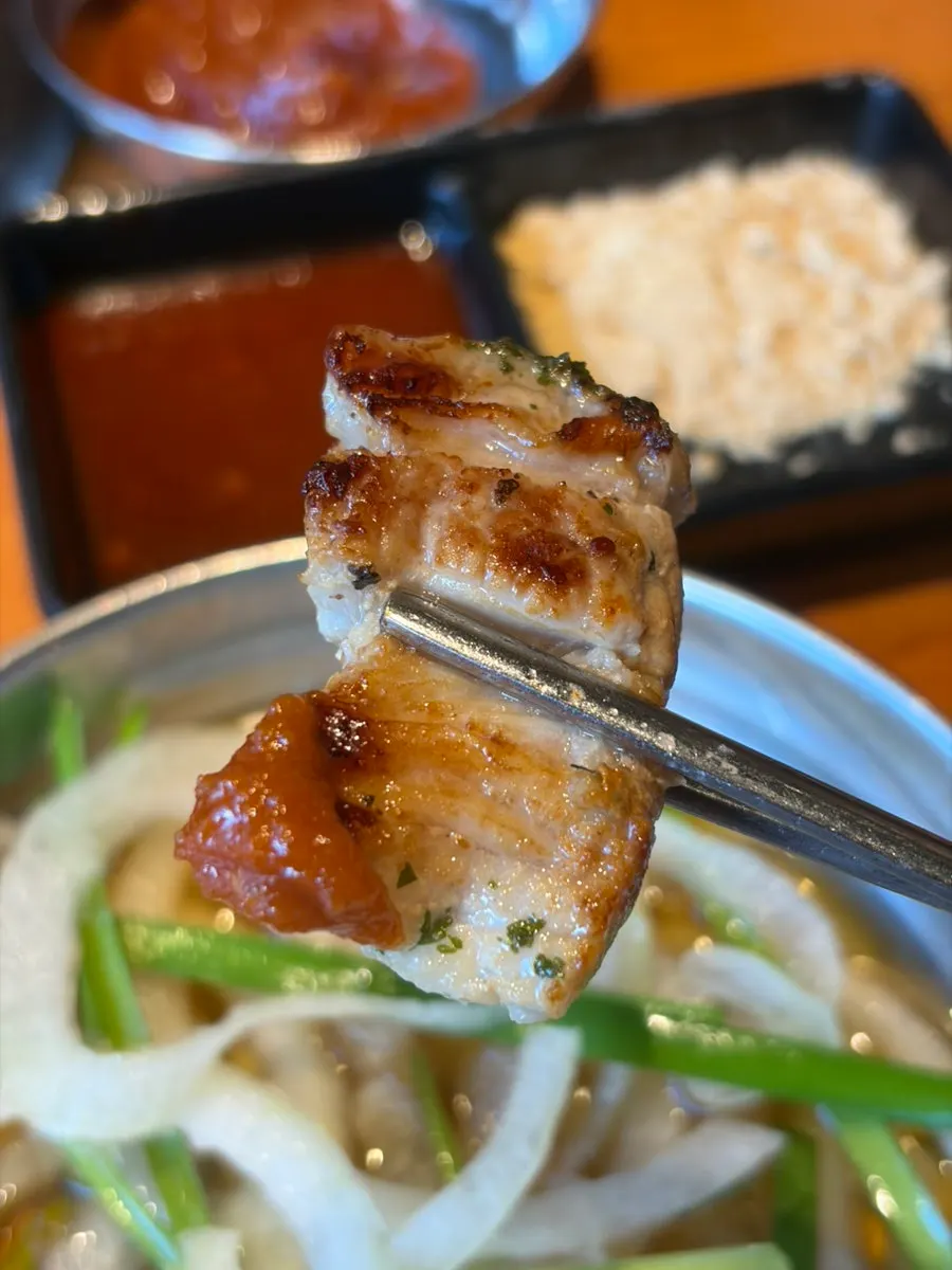Thick knife-cut pork belly pieces returned to the grill after cutting