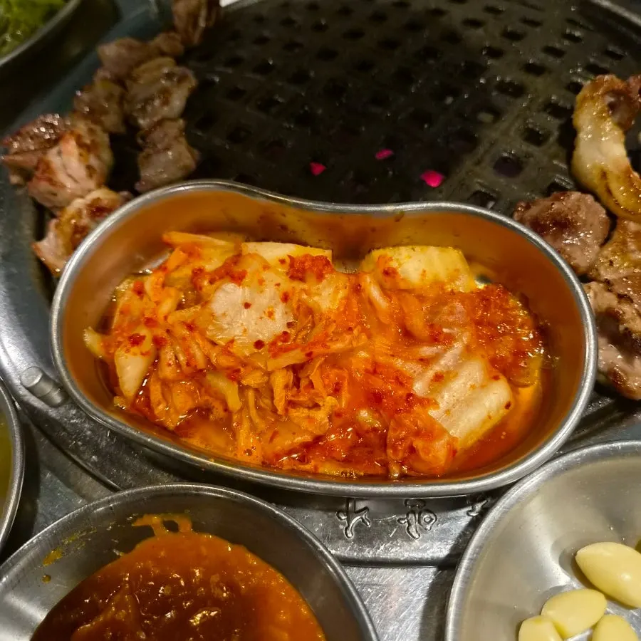 Grilled kimchi cooked alongside meat on the grill
