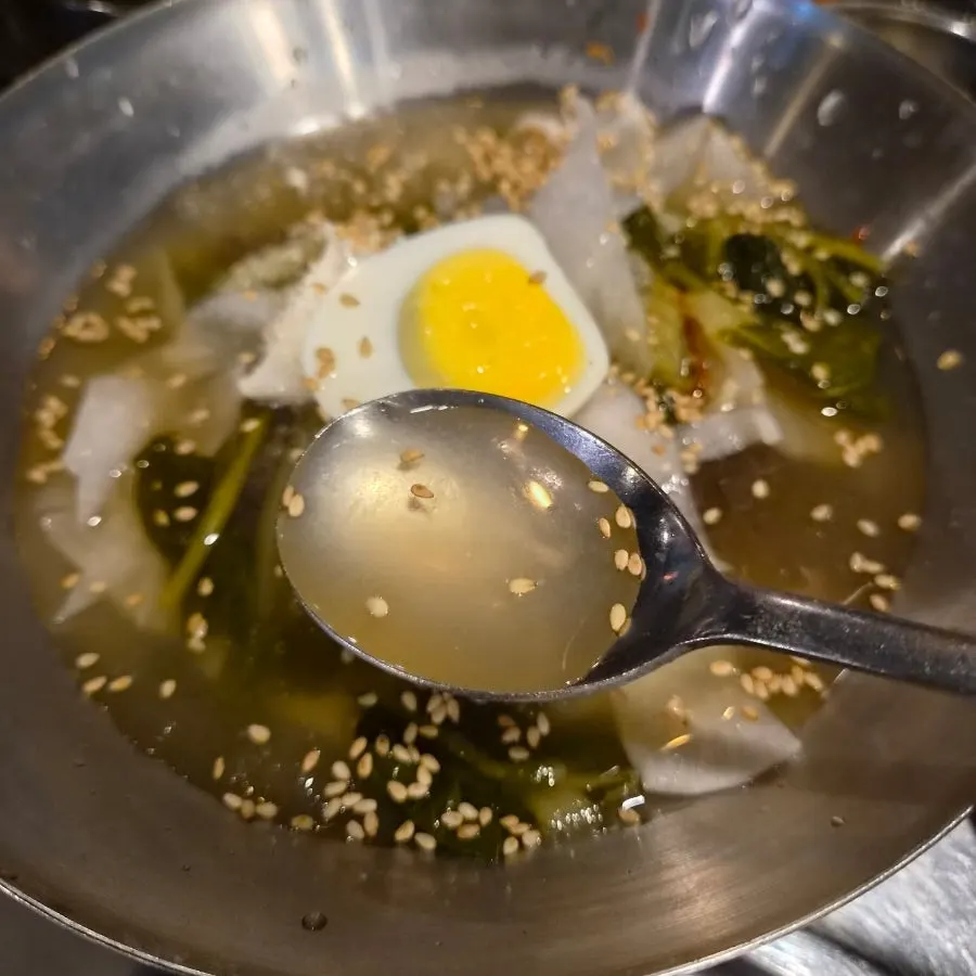 Mul-bibim naengmyeon topped with egg and pickled radish
