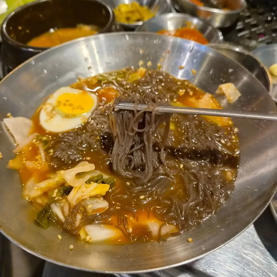 Noodle strands of the mul-bibim naengmyeon after mixing in the seasoning
