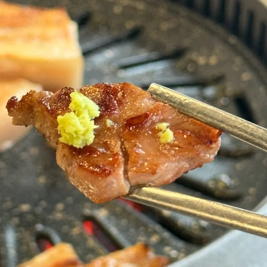 A grilled piece of meat with wasabi on top