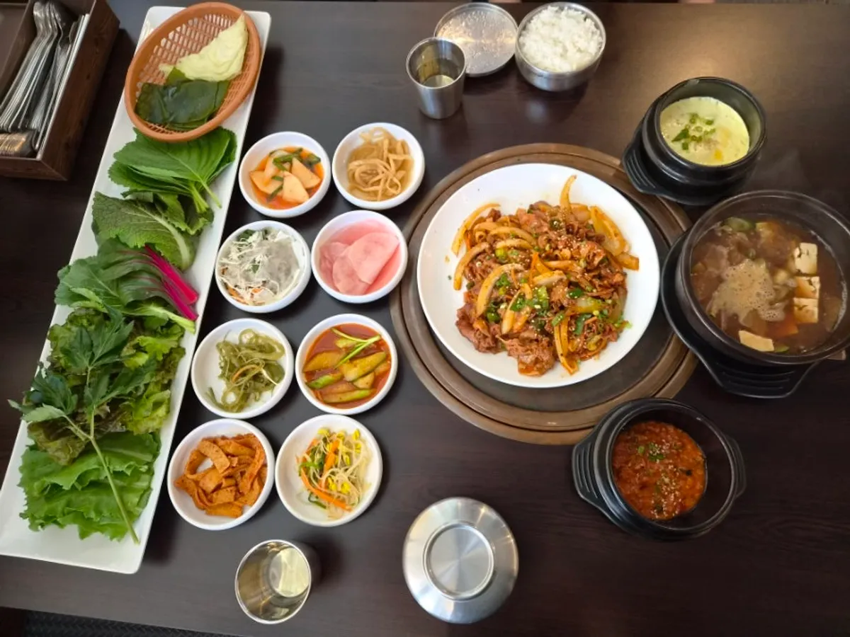 深石包飯的炒豬肉、白飯與包飯蔬菜擺桌