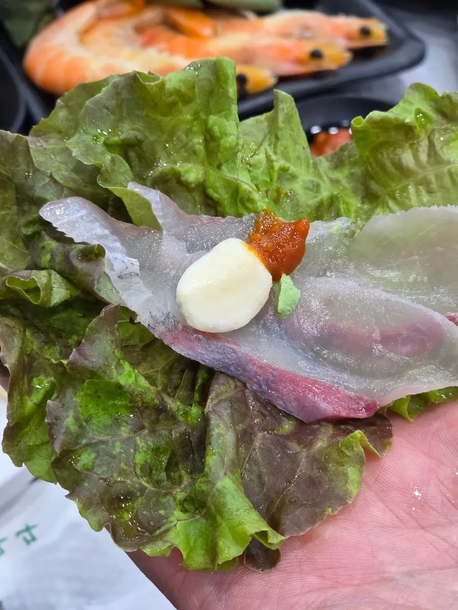 生菜包裹生鱼片、蒜片与包饭酱