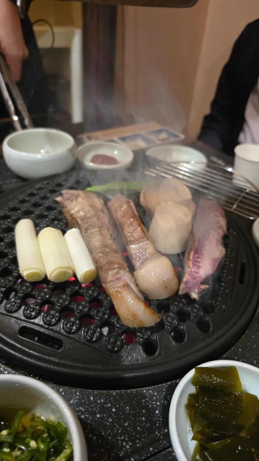 Thick cuts of aged pork grilling on the tabletop grill