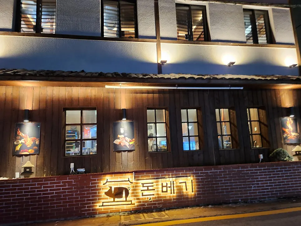 Wood-toned exterior of Donbegi Gwang-an Branch lit up in the evening
