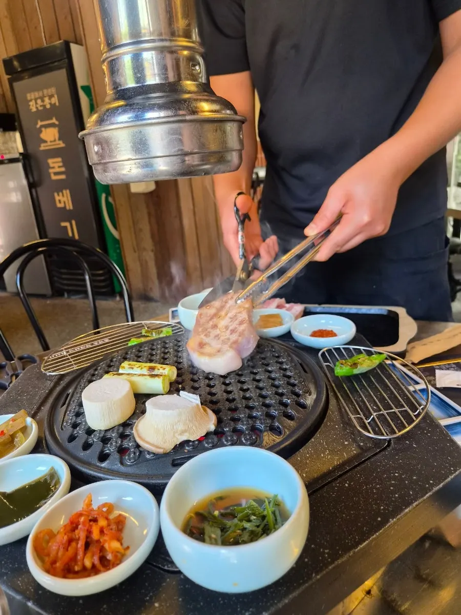 Staff grilling the meat with tongs and scissors