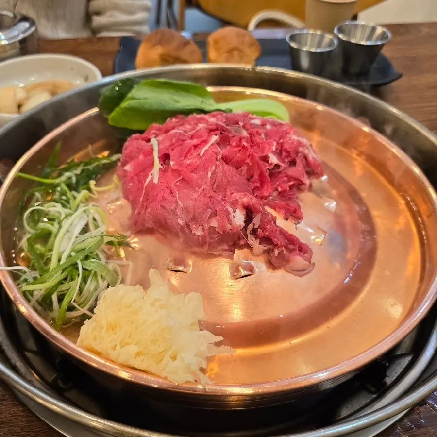 불판에 올라간 한우불고기와 채소, 당면