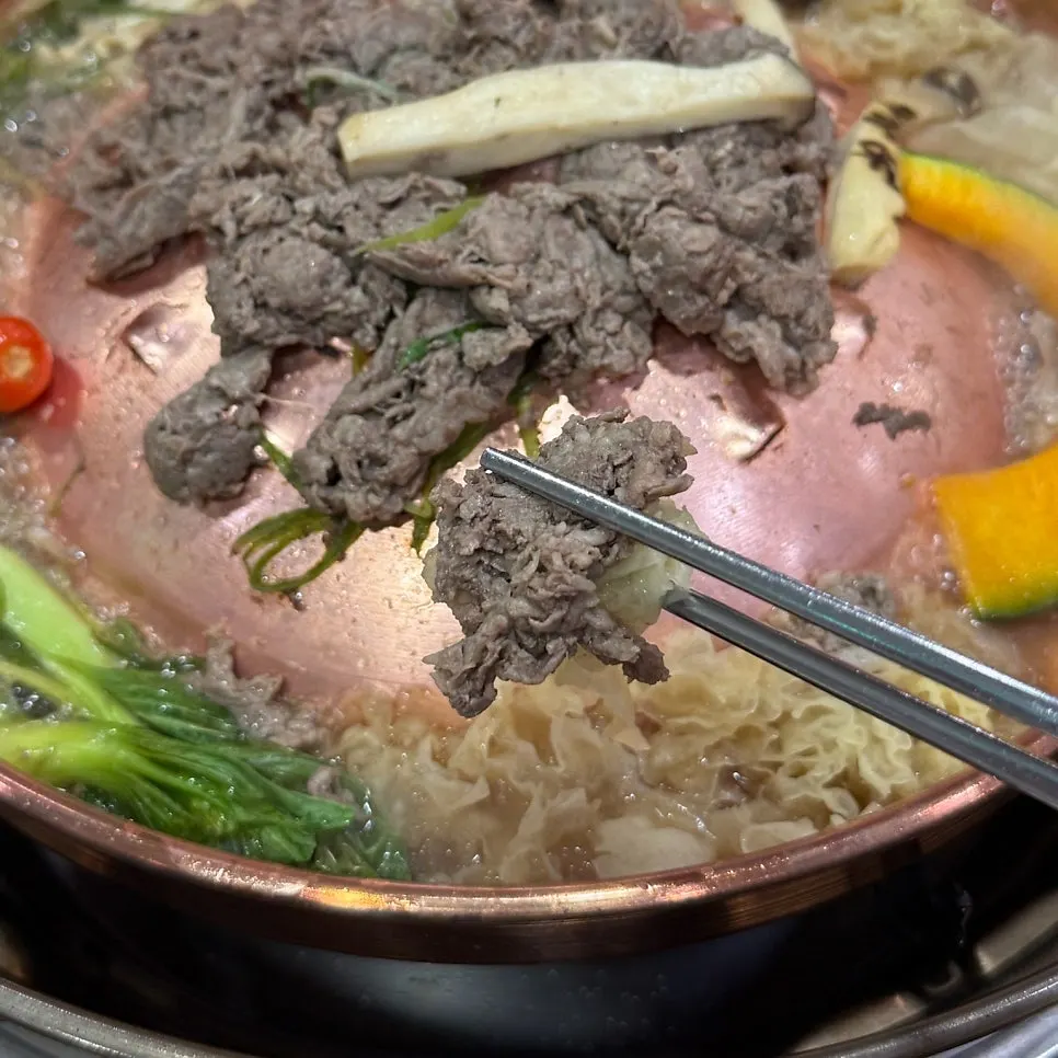 Bulgogi being cooked shabu-shabu style in the broth