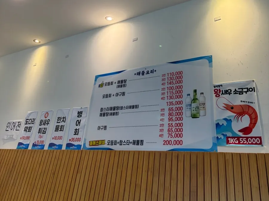 Menu board listing assorted sashimi and individual seafood dishes
