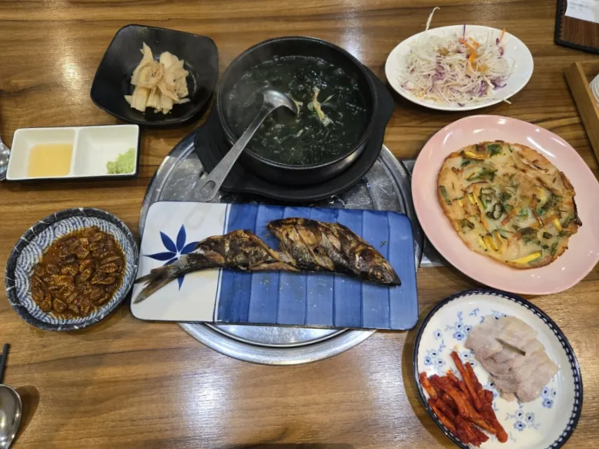 Table of basic banchan with seaweed soup, boiled pork, and jeon