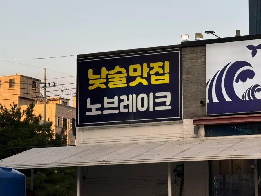 Exterior of Donghae Bada Hoetjip with a sign reading seasonal raw fish specialty restaurant