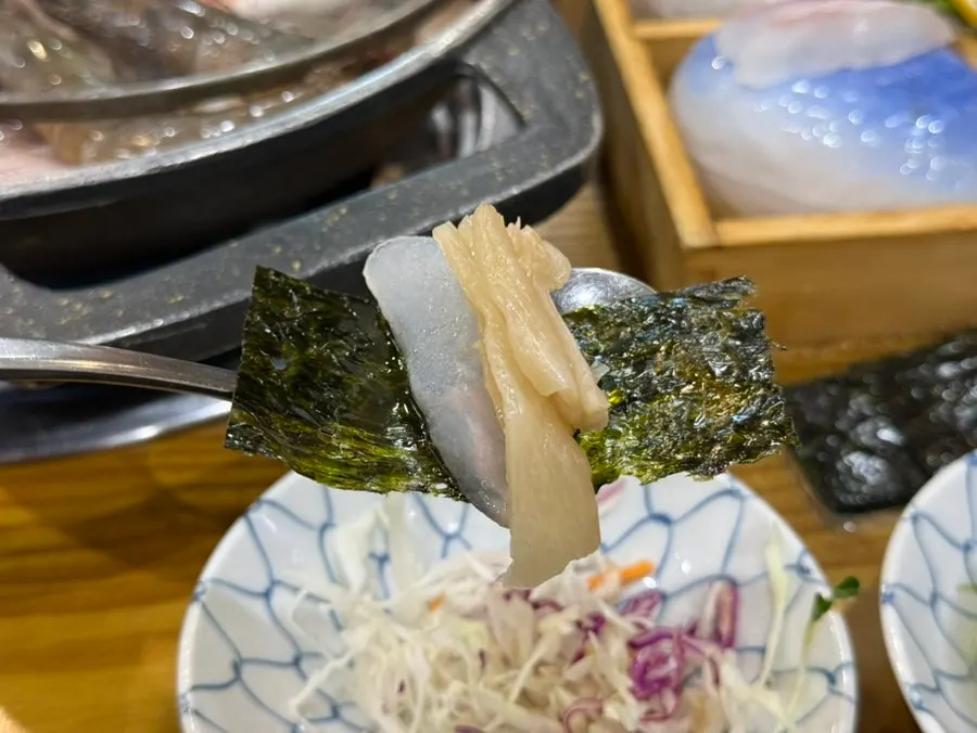 Seaweed and baek-kimchi served alongside the sashimi
