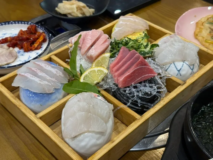 Wrapping sashimi and baek-kimchi together in seaweed