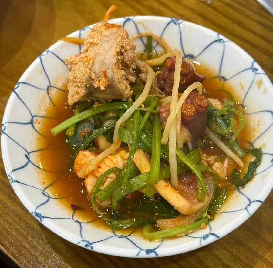 A spoonful of the spicy seafood stew broth