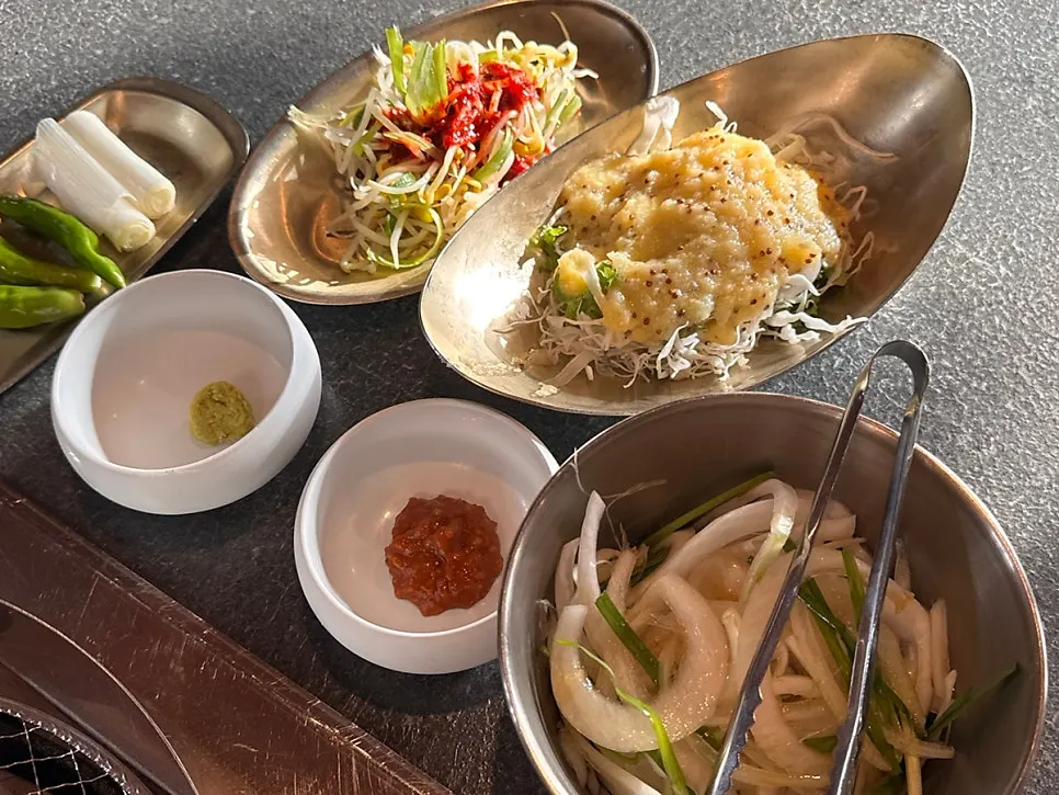 Basic table setting with salad and namul side dishes at Dongbaek Hanokjip