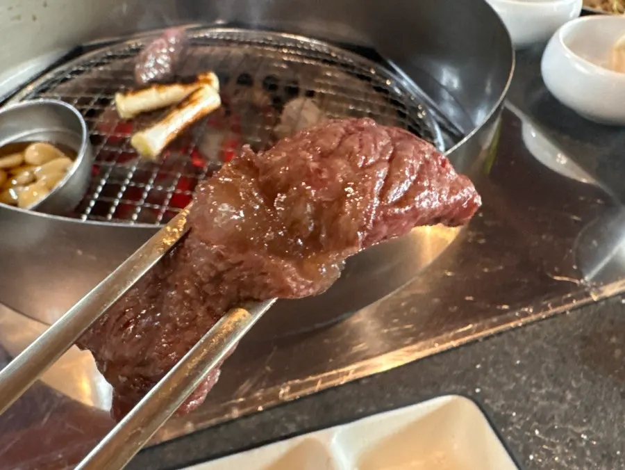 A single piece of grilled hanwoo chuck flap picked up