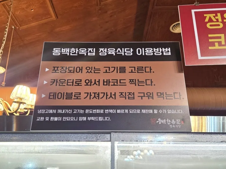 고기를 고르는 냉장고 앞 카운터