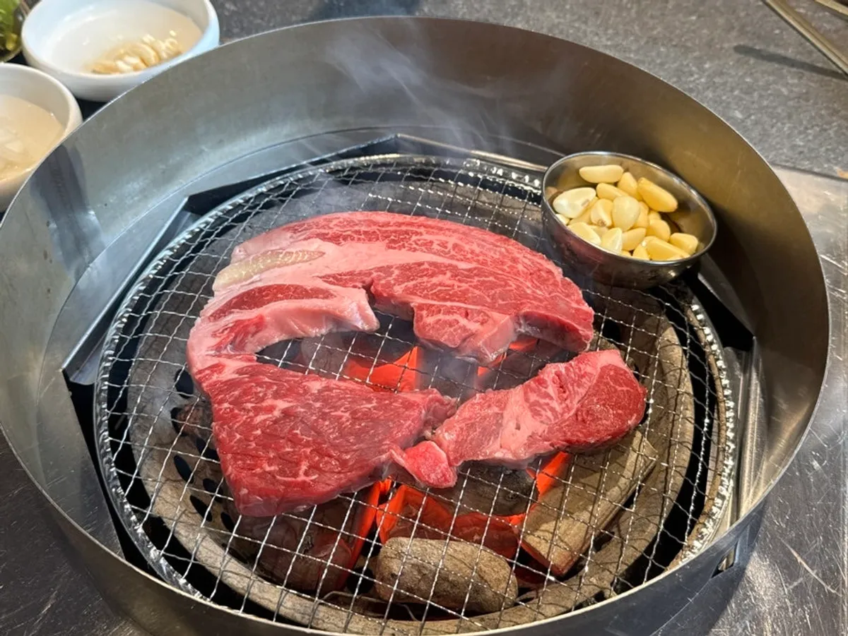 Exterior of Dongbaek Hanokjip charcoal-grill butcher restaurant and its large parking lot