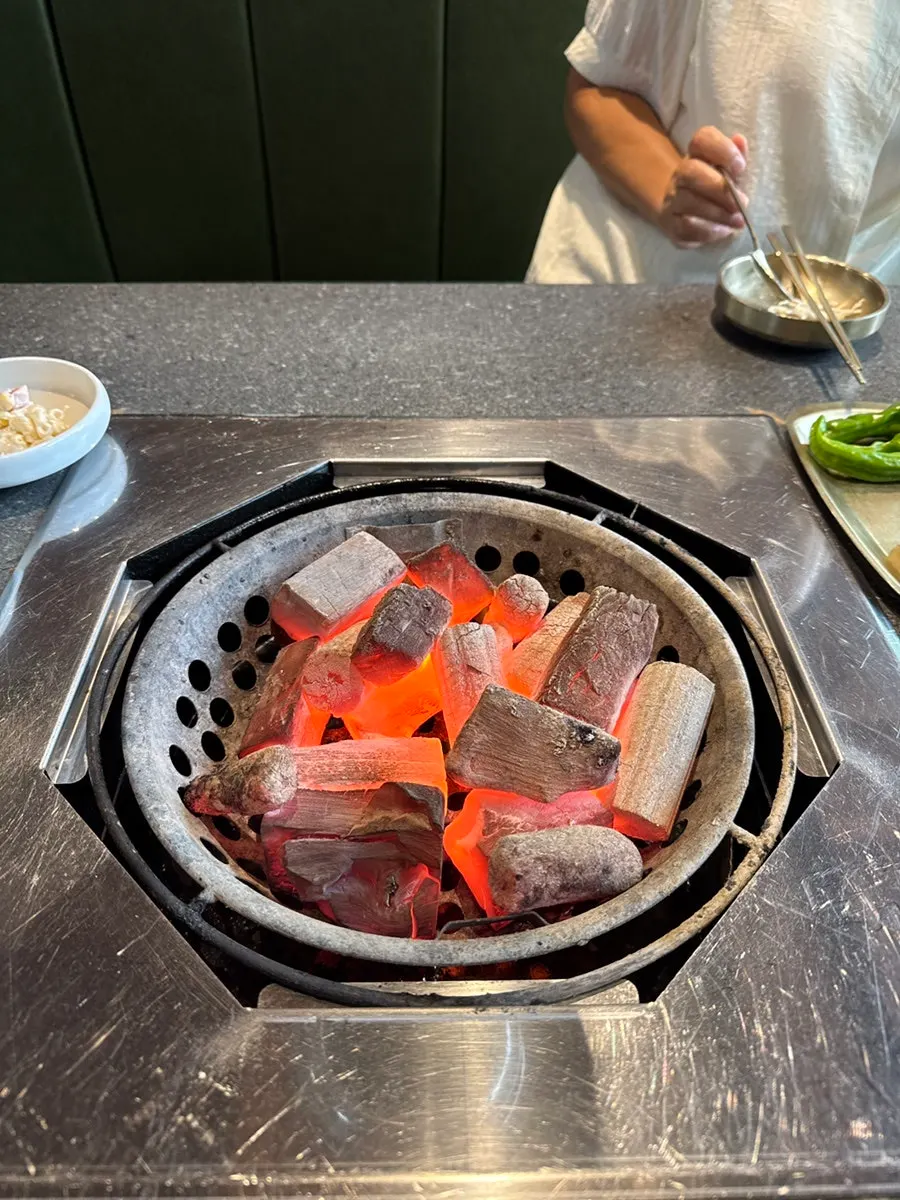 Kkotdeungsim placed on the fiercely hot charcoal grill
