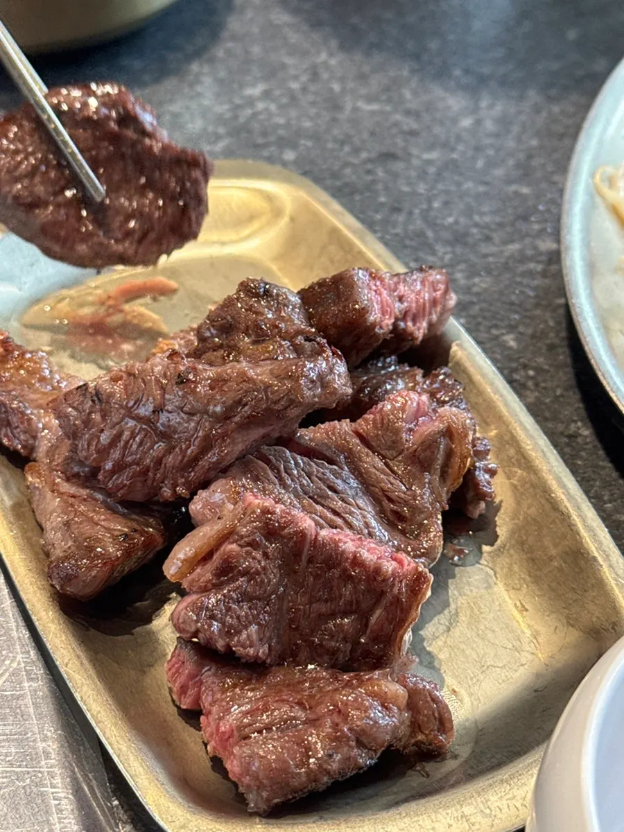 A piece of grilled kkotdeungsim dipped in salt