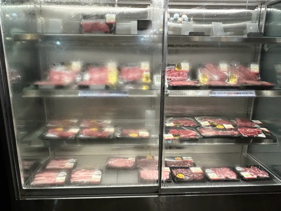 The wide meat display counter inside the store