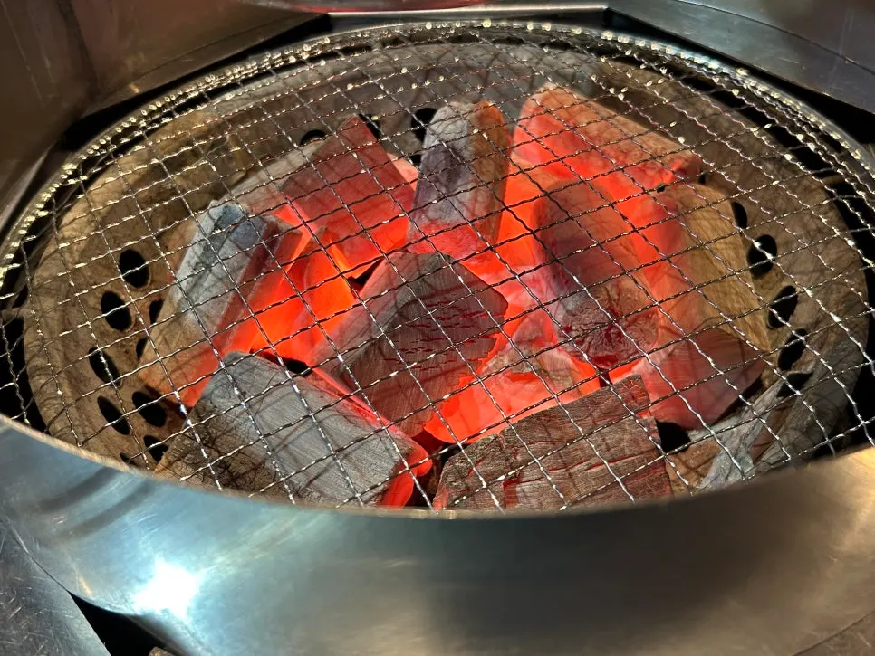 Iberico pork jowl grilling over charcoal