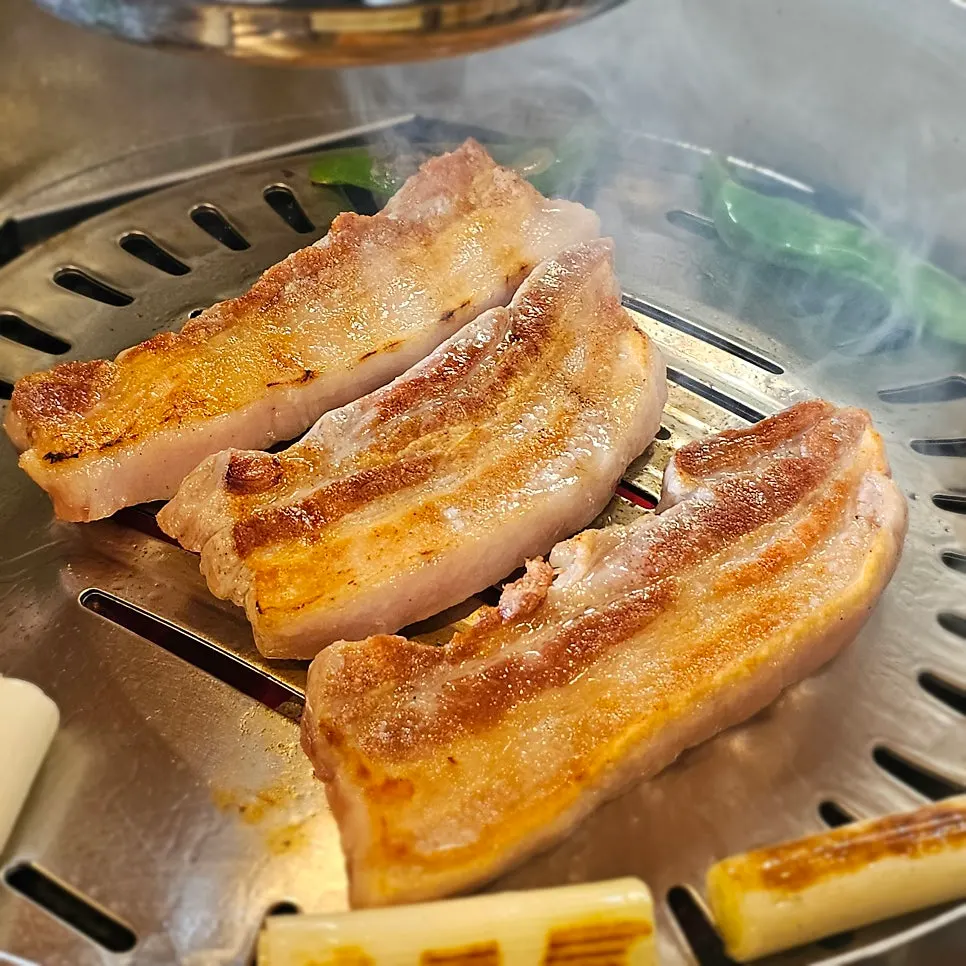 숯불 불판 위에서 구워지는 삼겹살
