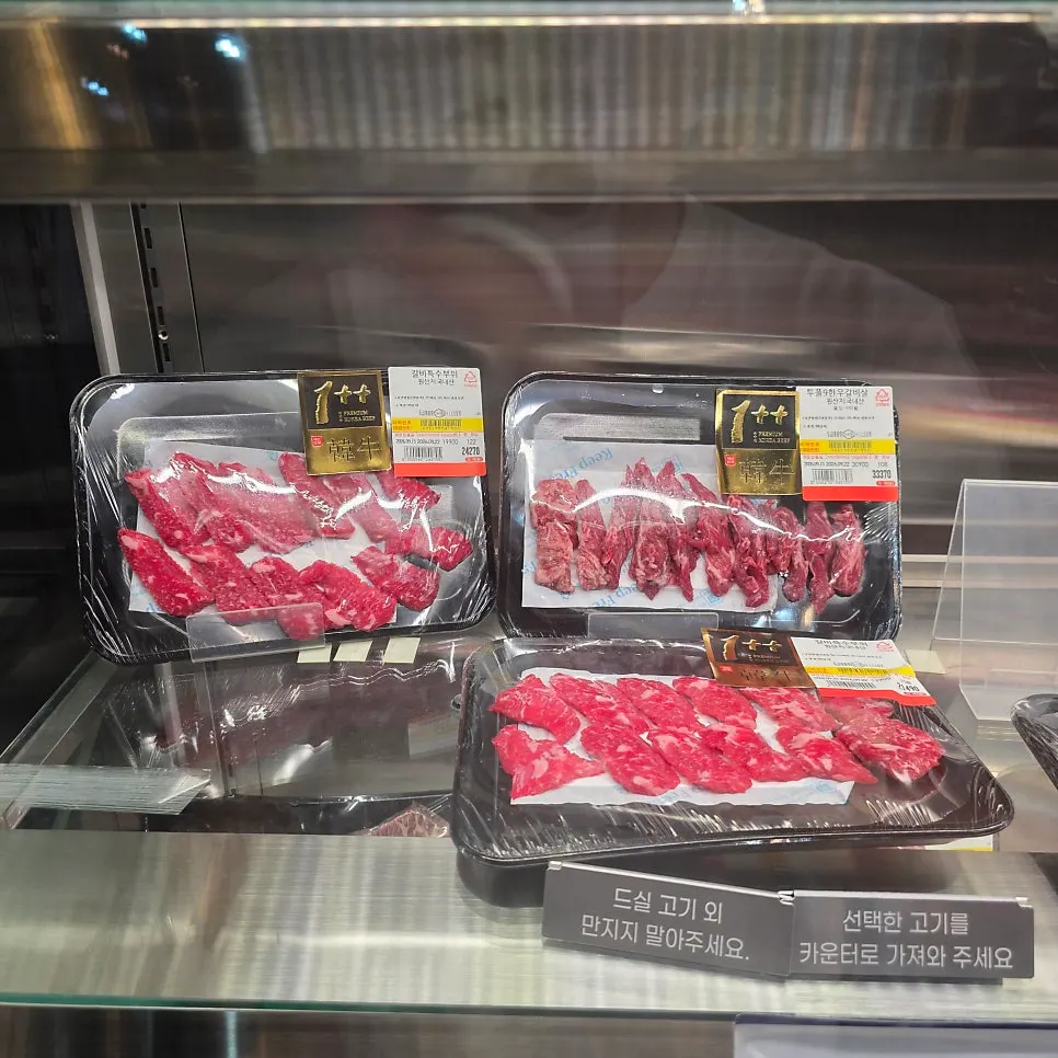 Meat packs at the butcher counter labeled with weight and price