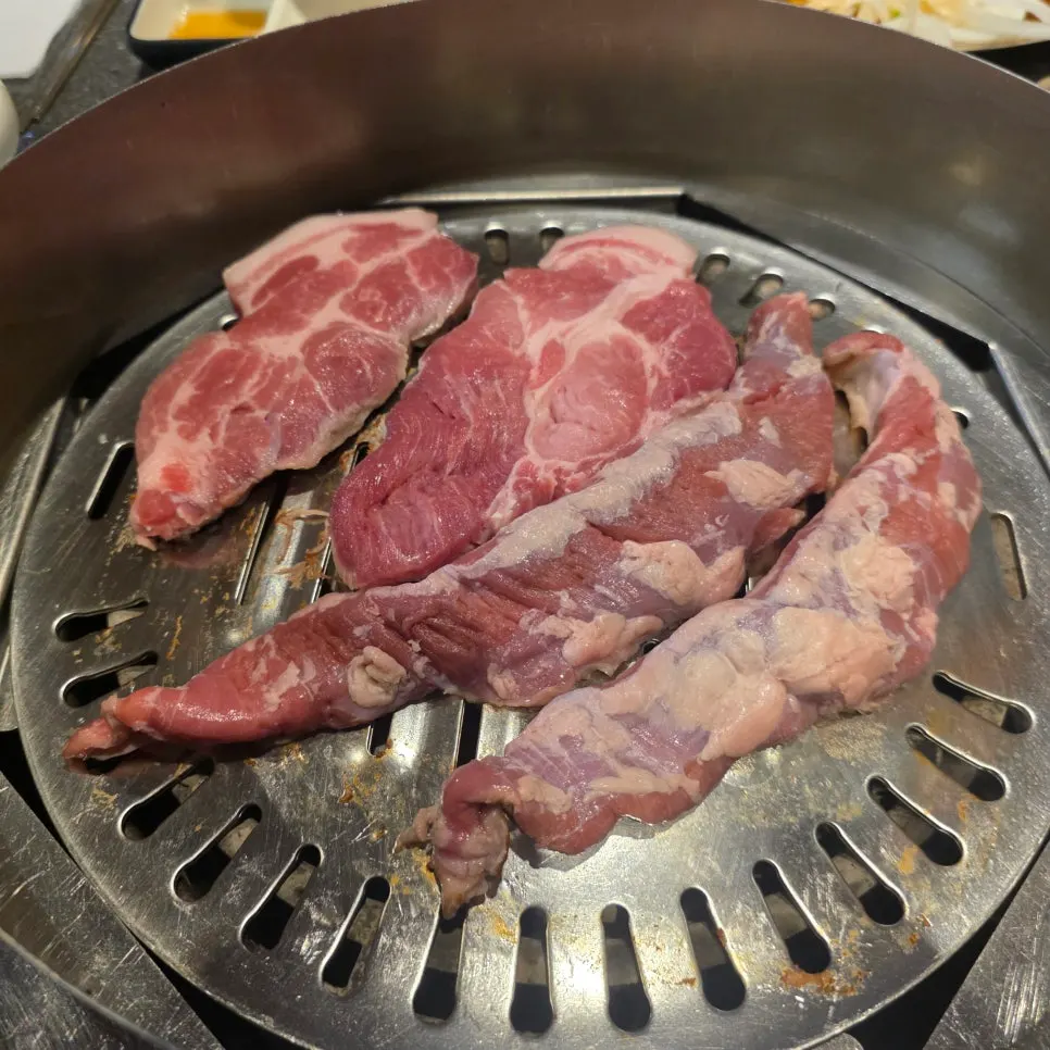 Korean pork neck grilling over charcoal