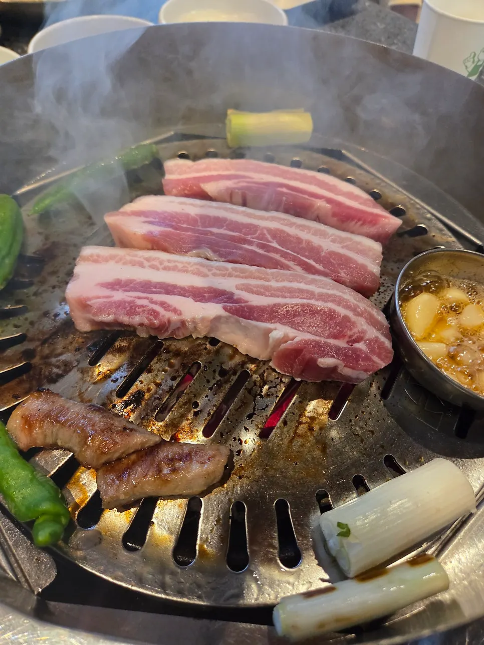 숯불 위에서 익는 두툼한 삼겹살