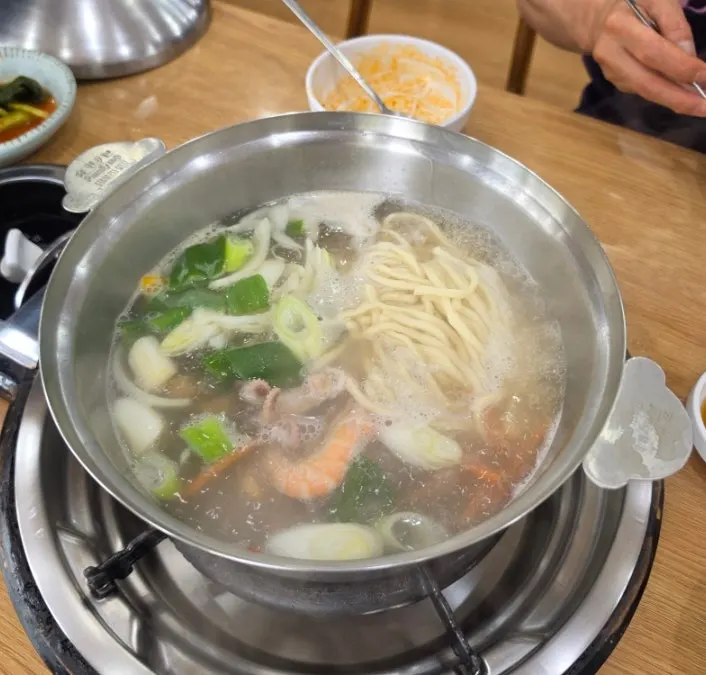 Pot of steaming seafood kalguksu