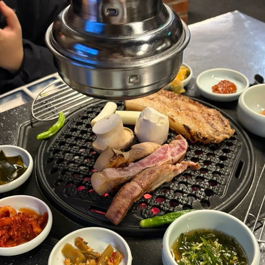 Staff grilling aged pork on the tabletop grill