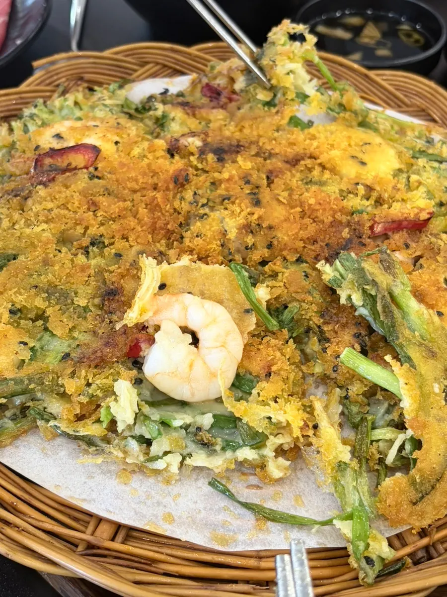 Hand-cut flat noodles being stretched out and added