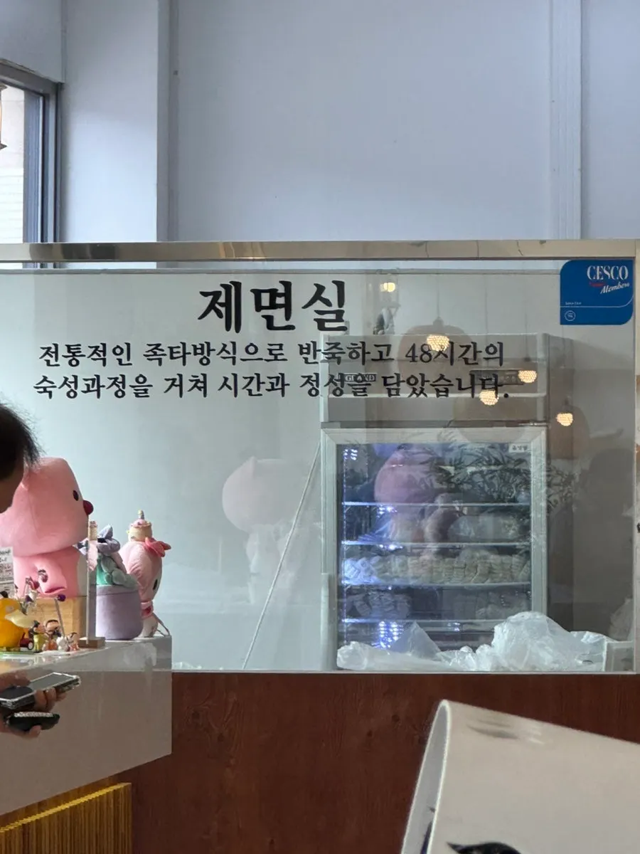 Self-serve corner with fresh kimchi, diced radish kimchi, and extra broth