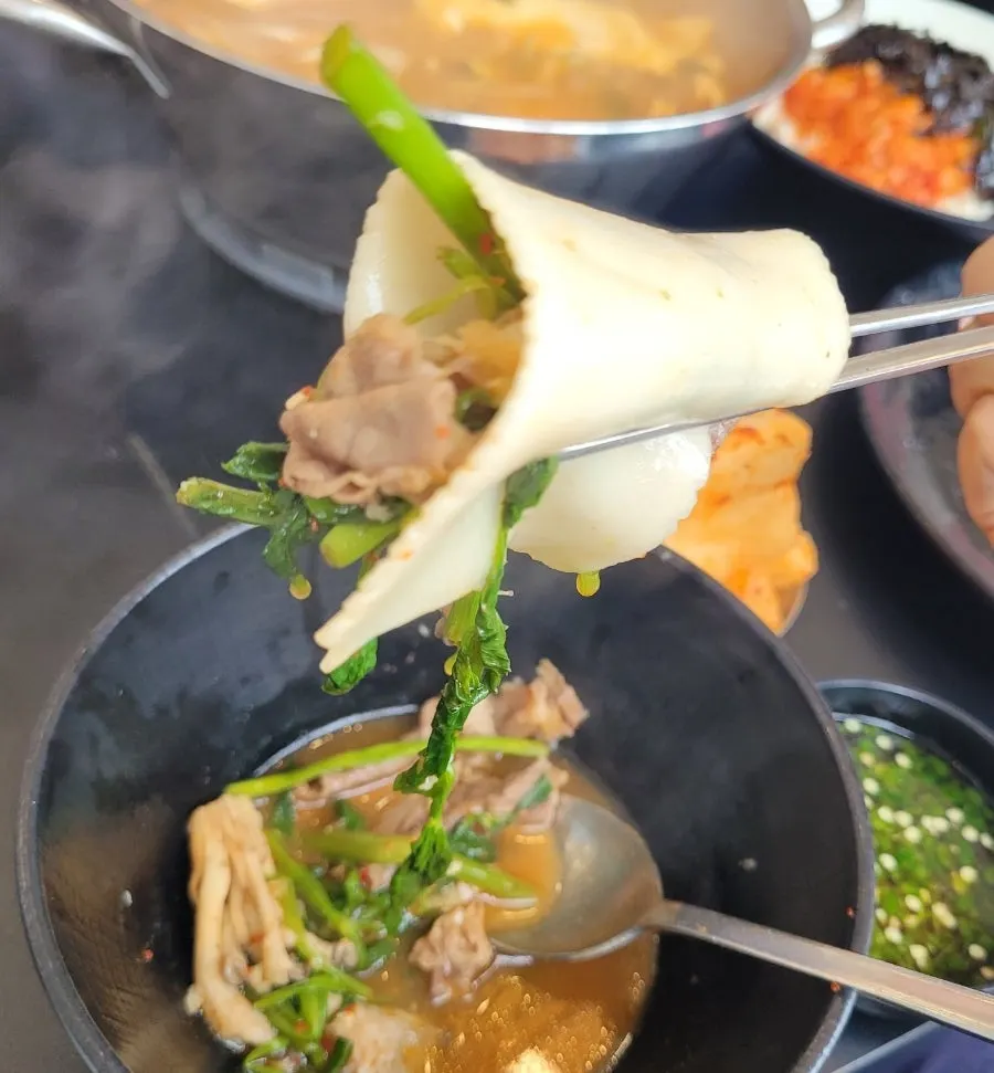Meat and vegetables piled on a flat noodle