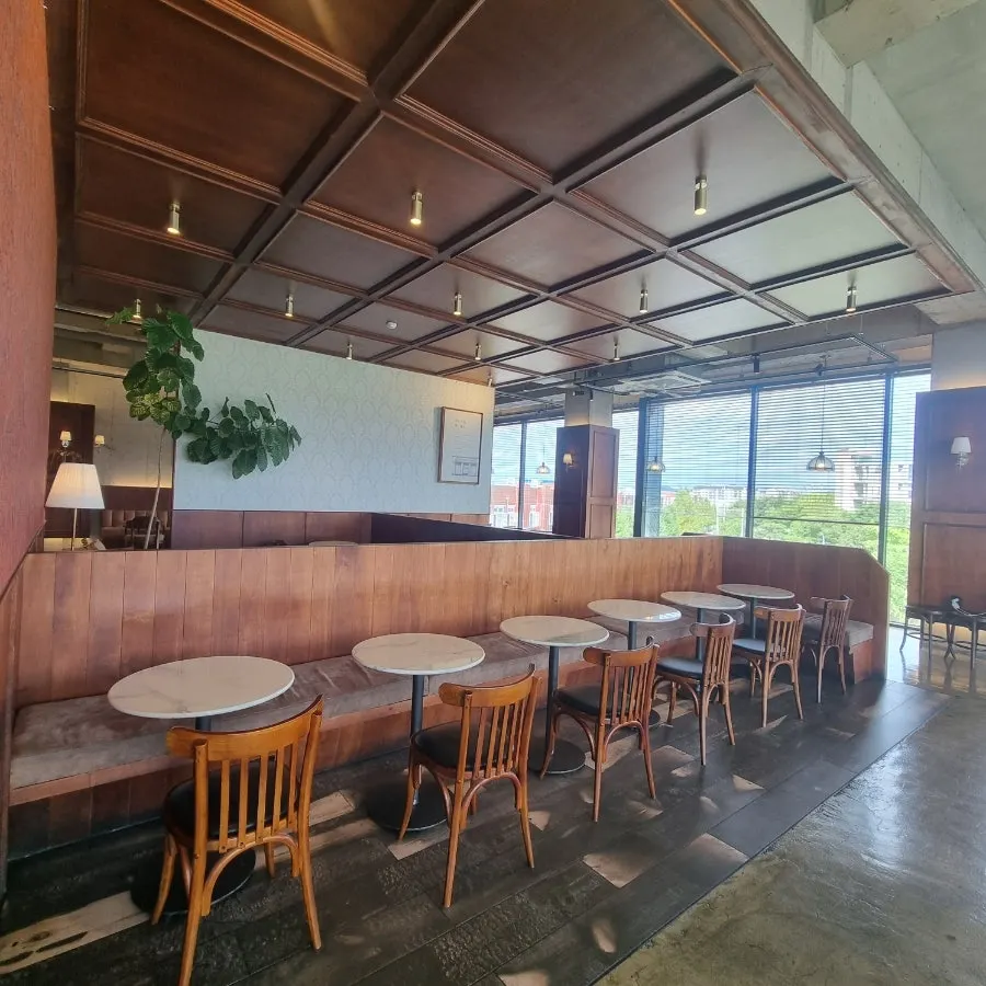 Second floor with green chairs, framed pictures, and mirrors