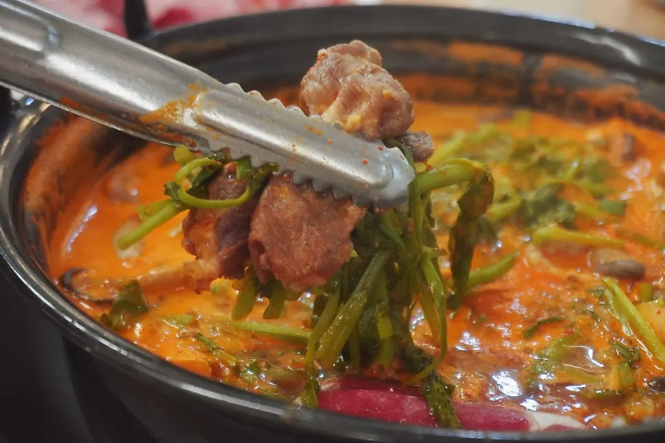 Daging shabu-shabu diambil menggunakan penyepit