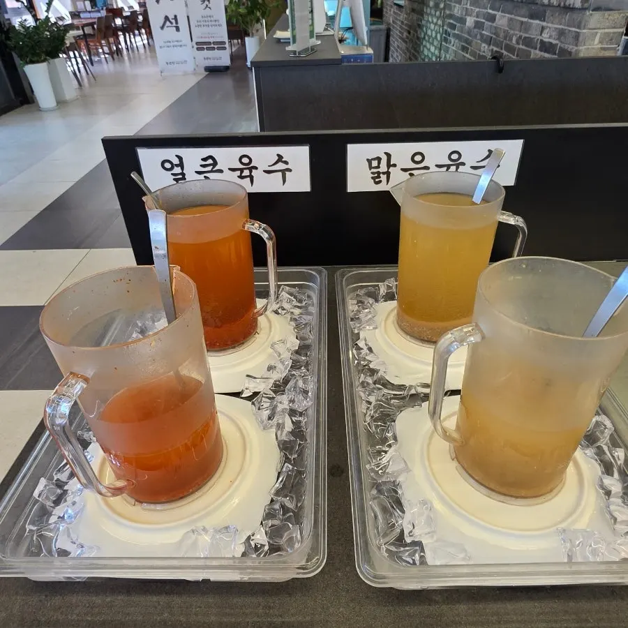 Self-bar with broth, sauces, and kimchi for guests to serve themselves