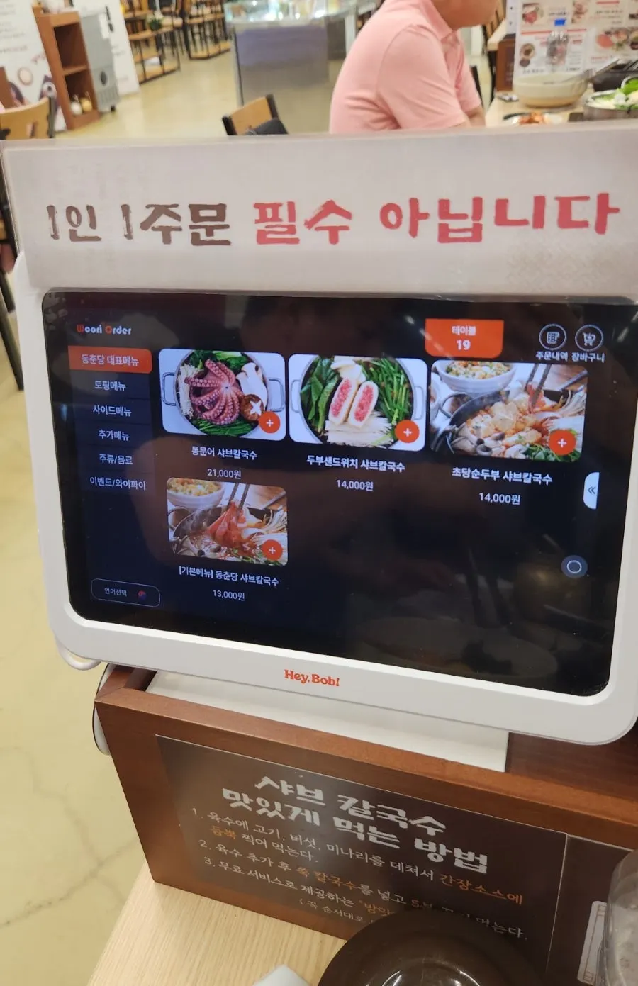 The kiosk ordering screen next to the table